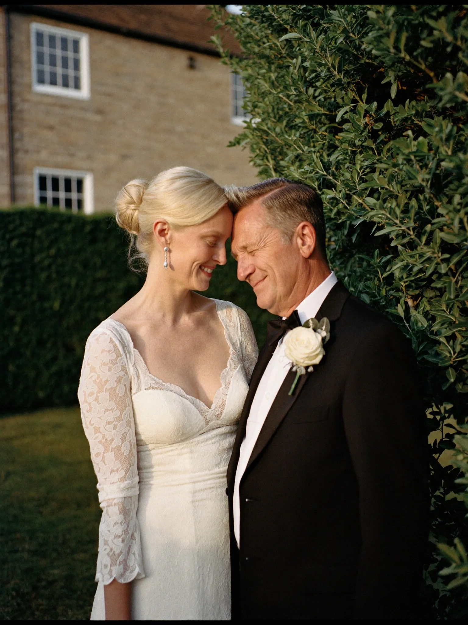 Editorial wedding portrait of a couple in a garden at golden hour